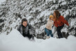 © qunica.com - Friends enjoying a snowball fight in a winter forest setting, sharing laughter and delightful moments together amidst the snow