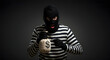 © suwatthana - burglar,  thief,  robber, Burglar in Striped Shirt and Balaclava Holding a Money Bag