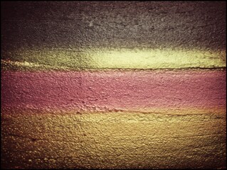 Leinwandbilder - Abstract close-up of textured painted wall with horizontal bands of color in warm tones and dark top
