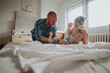 © qunica.com - A joyful family enjoys playful moments with their baby on a bed in a bright, cozy bedroom, exuding warmth and love.