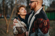 © qunica.com - A couple embraces outdoors, wearing warm jackets, sharing a genuine and affectionate moment in nature.