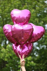 Aufkleber - A bunch of pink heart-shaped balloons floating in the air.
