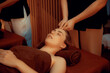 © InfiniteFlow - Caucasian woman enjoying relaxing anti-stress head massage and pampering facial beauty skin recreation leisure in warm candle lighting ambient salon spa in luxury resort or hotel. Quiescent