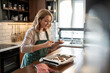 © Migma_Agency - Woman photographing homemade cookies in kitchen