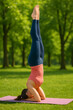 © Nayan - Young Woman Doing Sirsasana Yoga Pose – Headstand Practice on Yoga Mat Outdoors
