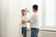 © New Africa - Handsome man looking at himself in mirror indoors