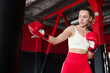 © New Africa - Boxing. Woman practicing with punching bag in training center