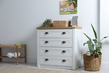 Poster - Dresser with stylish decor and houseplants near white wall indoors