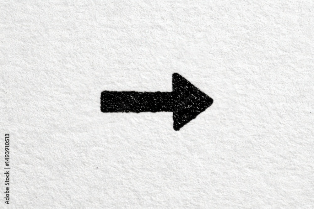 A bold black arrow is drawn on a textured white paper, clearly indicating a rightward direction. The contrast between the black ink and white background highlights the arrows shape and intention.