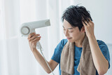 ドライヤーで髪を乾かす若い男性