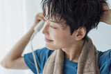 ドライヤーで髪を乾かす若い男性