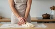 © Yuudaishin - Middle‑aged man kneading bread dough inside a minimalist home kitchen