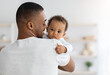 © Prostock-studio - Father's love. Young afrian american dad holding his sweet infant baby in hands, closeup shot of caring black millenial dad spending time with cute adorable toddler child at home, copy space