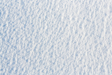 Wall Mural - Natural snow texture. The surface of an icy snow crust. Snowy ground. Winter background with snow patterns. Perfect for Christmas and New Year design. Closeup top view.
