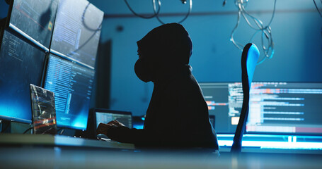 Poster - Night, hacking and person with hoodie, computer and programming of cyber attack, screen and system. Mysterious, criminal and typing of scam for ransomware, anonymous and hacker with tech for phishing