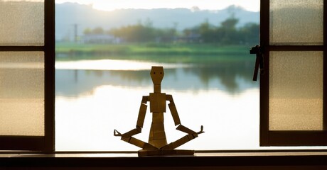 Poster - Paper figure sits meditating near window. Landscape visible outside, calm water reflects sunlight. Peaceful scene evokes serenity.