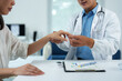 © Phimwilai - Doctor examining patient's hand in medical office, providing healthcare and medical attention