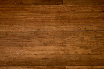 Wall Mural - A wooden floor with a grain pattern. The floor is brown and has a few scratches. The wood is old and has a natural look