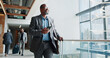 © peopleimages.com - Happy, businessman and walking with phone or suitcase for travel, job opportunity or career trip at airport. Man, employee or traveler with smile, mobile smartphone or luggage for commute or flight