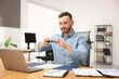 © New Africa - Man taking photo of document using scanning app on smartphone at desk in office