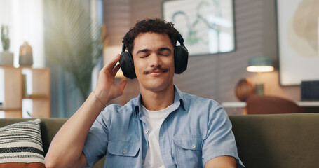 Poster - Relax, music and man with headphones in home for streaming service, hip hop playlist or podcast. Technology, sofa and happy person listening to audiobook, song or audio with sound on weekend to chill