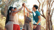 © peopleimages.com - Happy people, fitness and high five in huddle for workout goals, winning or teamwork in nature. Active, group or friends with smile or motivation for success, exercise or health and wellness together