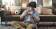 © peopleimages.com - Vr headset, video games and man with controller, home and fun with virtual sport in living room and online. Futuristic, gamer and person with tech for entertainment, streaming and player with console
