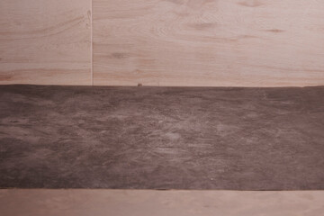 Wall Mural - A wooden floor with a grey carpet on top. The floor is made of wood and has a slightly worn appearance