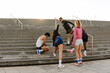 © Drobot Dean - A group of five athletes are warming up and stretching while standing on the stairs outdoors