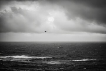 Poster - Dramatic monochrome seascape featuring a mysterious unidentified flying object hovering above the vast ocean under a cloudy sky, creating a sense of wonder and intrigue.