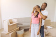 © anatoliycherkas - African American Man surprising woman covering her eyes in new apartment