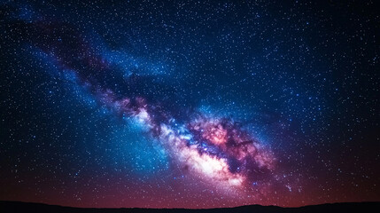 A stunning view of the colorful Milky Way galaxy stretches across the night sky filled with twinkling stars.