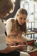 © dsheremeta - Senior woman helping young apprentice making pottery on spinning wheel