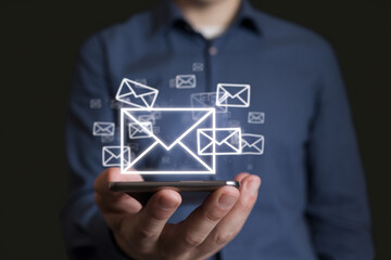 Aufkleber - Person holding a phone with email icons floating above it against a dark background in studio shot