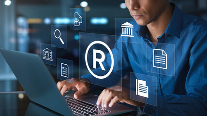 Poster - Man using laptop with trademark symbol and document icons floating above keyboard in blue lighting