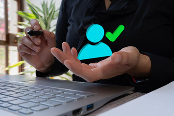 Poster - Businesswoman with computer, pointing and holding a 3D icon of a person with a check mark