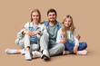 © Pixel-Shot - Happy family in stylish denim clothes sitting on brown background
