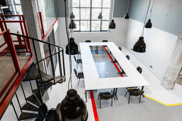 Poster - Modern conference room design with large table and industrial lighting in a spacious setting