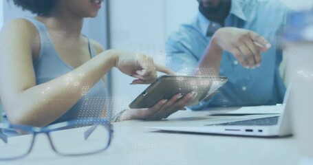 Poster - Two co-workers tapping tablet screen and comparing business data on laptop display