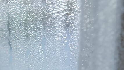Poster - Close-up video of a steamy translucent glass surface covered in water condensation, showcasing a wet, blurred effect and bright highlights