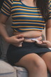 © Kansuda - Cropped shot of woman touching and squeezing her fat belly.