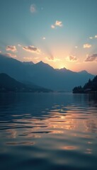 Poster - Serene mountain lake sunset with reflections on water and soft clouds in the sky, creating a peaceful nature scene.