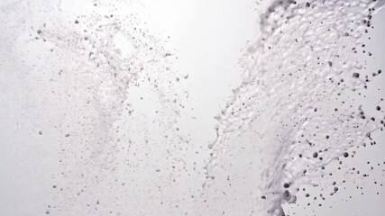 Poster - Water fountain spraying stream upwards against a white backdrop with multiple water droplets catching the light.
