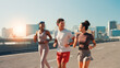 © peopleimages.com - Happy people, fitness or running in city street for exercise, cardio workout or outdoor training. Active group, friends or runners with smile on road for physical health and wellness in an urban town