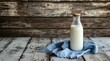 © AT - A glass bottle of milk sits on a rustic blue cloth, against a weathered wood backdrop