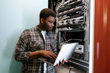 Poster - Technician configuring server settings in a data center during the day