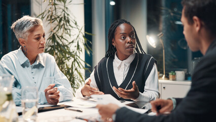Poster - Documents, night and business people in meeting in office for financial review, budget report and feedback. Corporate, overtime and workers with paperwork for collaboration, strategy and planning