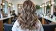 © Sona - A woman with wavy blonde hair in a salon with mirrors and clients, focusing on hairstyling and beauty services.
