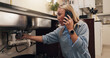 © WesleyStudy/peopleimages.com - Woman, phone call and stress by kitchen sink for leak, emergency and talk with shock at apartment. Person, smartphone and contact for repair, help and plumbing services for drain in morning at house