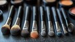 © IsabellaNoviDwita - Aesthetic display of makeup brushes and face powders on a sleek dark surface